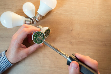 man repairing led lamp. close-up view on hands