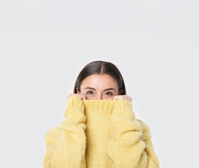 Young woman in stylish yellow sweater on white background