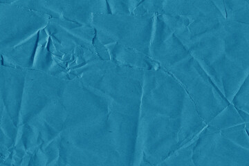 Blue vintage and old looking crumpled paper background. Retro cardboard texture. Grunge paper for drawing. Ancient book page. Present wrapping.