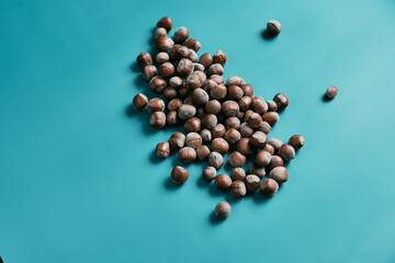Fresh Peeled Hazelnuts on aqua menthe color background. Concept of autumn harvesting. Natural and...