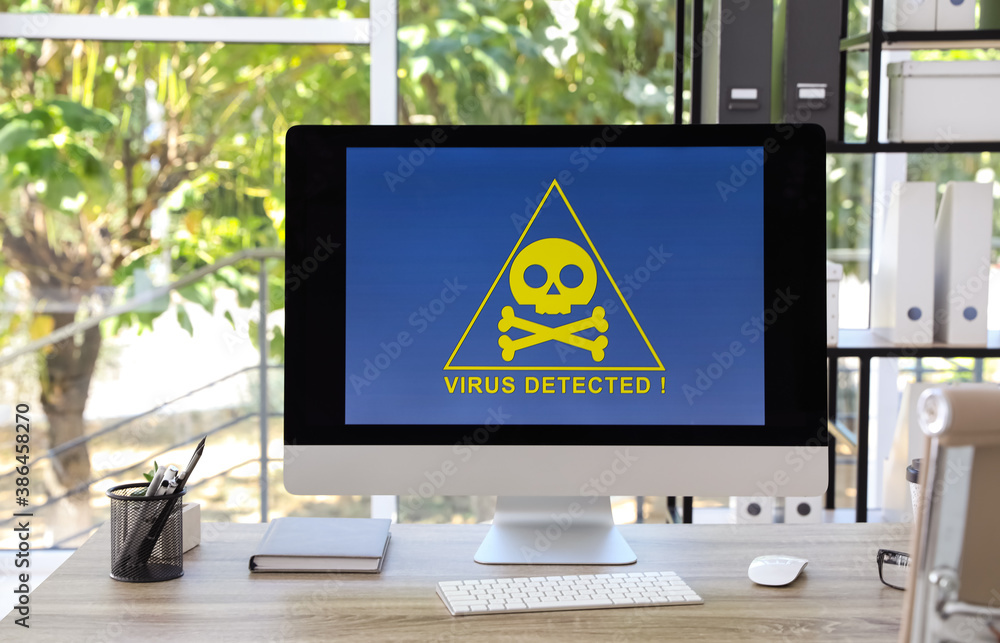 Poster computer with warning about virus attack on screen in office