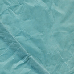 Blue vintage and old looking crumpled paper background. Retro cardboard texture. Grunge paper for drawing. Ancient book page. Present wrapping.