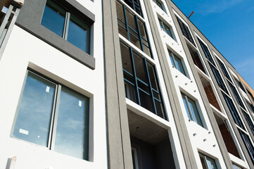 part of the facade with Windows of a new house with gray walls
