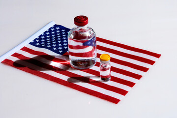 Bubbles with clear liquid on the background of the American flag. The concept of a vaccine to protect against infection.