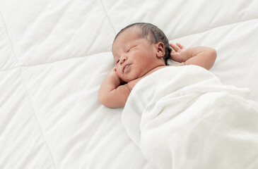 Portrait of african infant sleeping on bed