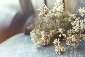 Abstract image with reflection - Gypsophila Baby breath flowers with masses of small white flowers on grey textured woodenchair. Shallow depth of field. Selective focus, copy space. Conceptual art.
