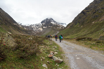 Fototapeta premium Group of people hiking and mountain snow panorama in Tyrol Alps, Austria