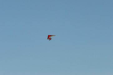 Fototapeta na wymiar Motorized hang glider flying free in the sky