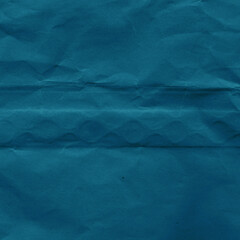 Blue vintage and old looking crumpled paper background. Retro cardboard texture. Grunge paper for drawing. Ancient book page. Present wrapping.