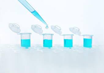 Test tubes with blue liquid and a pipette with a clean transparent drop of water during the...