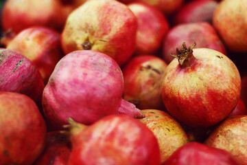 pile of pomegranates sold at fruit market, food background