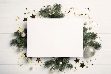 Flat lay composition with Christmas decor and blank card on white wooden table. Space for text