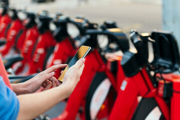 hands consulting phone in a bike rental station