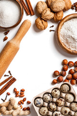 Ingredients for making a sweet pie or cookies with nuts on a white table top view. Free space for text. Various nuts, flour, sugar, eggs and cinnamon flat lay. Food background. Copy space.