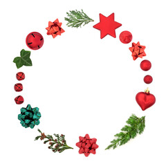 Christmas wreath with winter cedar, fir & ivy with red bauble decorations & gift bows on white background. Minimal symbol for the xmas season. Top view, flat lay, copy space.