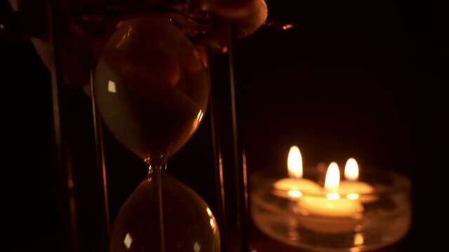 Hourglass and floating candles as a slower Time Lapse , candle lights are flickering then extinguishing and getting all dark.You can find super fast version of the same clip at my portfolio.
