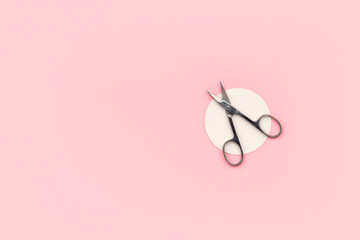 Flat lay top view scissors for manicure on pink background