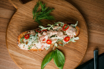 Fototapeta na wymiar Italian tomato bruschetta with chopped vegetables, herbs and butter on toast or toasted ciabatta bread.