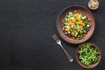 Delicious healthy pumpkin salad with arugula and cheese. Creative atmospheric decoration