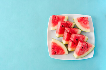Water melon slices on a plate on blue background