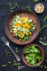 Delicious healthy pumpkin salad with arugula and cheese. Creative atmospheric decoration