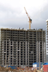 Fototapeta na wymiar Construction of modern multi-storey buildings. New development of a residential area. House frames, construction cranes and building materials at the construction site.