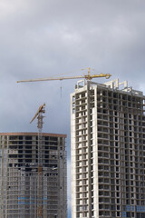 Fototapeta na wymiar Construction of modern multi-storey buildings. New development of a residential area. House frames and construction cranes at the construction site.