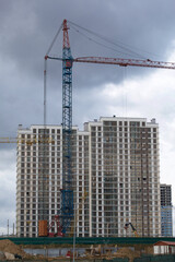 Fototapeta premium Construction of modern multi-storey buildings. New development of a residential area. House frames, construction cranes and building materials at the construction site.