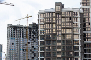 Fototapeta premium Construction of modern multi-storey buildings. New development of a residential area. House frames and construction cranes at the construction site.