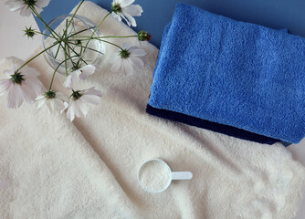 Bouquet of delicate flowers with Terry towels and washing powder,blue background, top view