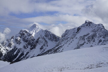 Fototapeta na wymiar Aussicht auf die österreichischen Alpen mit Schnee im Sonnenlicht und Wolken