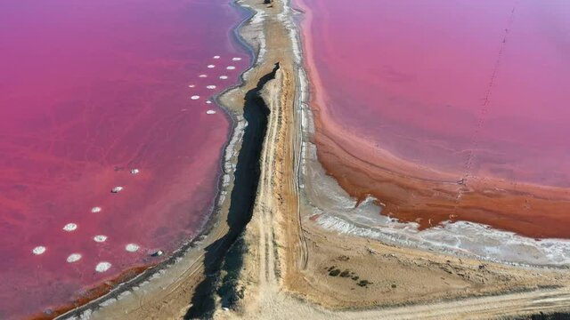 Aerial video flying over pink salt lake water from drone. Genichesk, Ukraine. 4k UHD footage