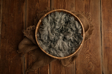 Newborn photography digital background prop. wood basket with green fur and on a wooden background
