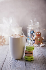White cup of coffee with marshmallow and macaroni in new year concept