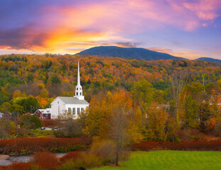 Colorful sky and fall foliage surrounding Stowe Church in Vermont 
