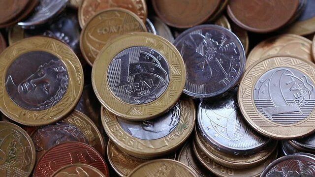 Close up e giro com moedas de real do Brasil