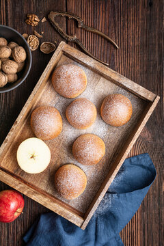 Sweet baked buns with apple and walnut filling, sprinkled with powdered sugar