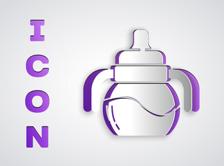Paper cut Baby bottle icon isolated on grey background. Feeding bottle icon. Milk bottle sign. Paper art style. Vector.