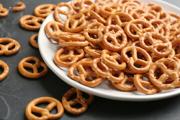Delicious pretzel crackers on black table, closeup