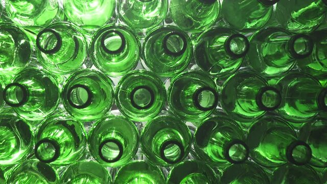 Empty bottles. Slider shot of empty glass bottles. Top view in production line. Empty green beer bottles, the top view ,Dolly shot, Shot in 4K UHD