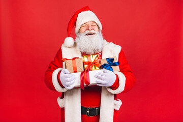 Photo of happy Santa Claus with present gift boxes lsolated over red background. Christmas and New Year concept.