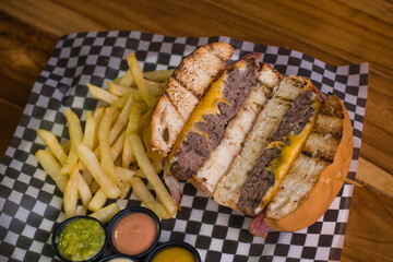 Hamburguesa de res con picanha, queso mozzarella y cheddar con tocineta,  papas a la francesa, salsas y guacamole