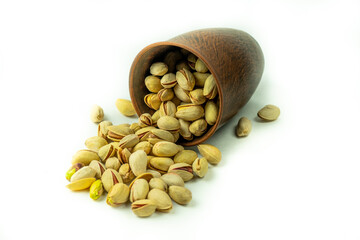 Natural pistachios in a ceramic bowl. Isolated on a white background