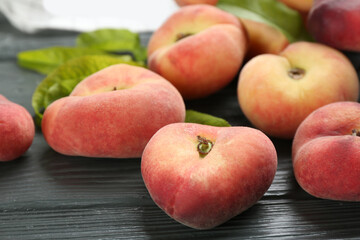Fresh ripe donut peaches on grey wooden table, closeup