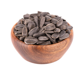 Sunflower seeds isolated on white background. Pile of fried sunflower seeds in wooden bowl.
