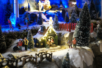 Miniature of winter scene with Christmas houses, people, trees, Christmas concept.