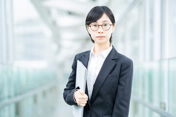 スーツを着て、緊張した表情をしている若い女性