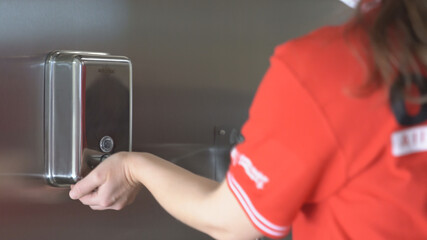 A woman worker wash her hands with soap . 