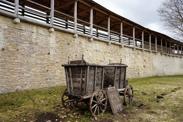 a small wooden cart on the background of the wall of the Izborsk fortress