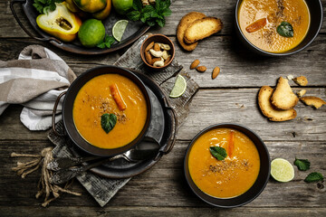 light summer soup with baked peppers, carrots and cheese, lime juice and ginger, served with nuts and fresh mint, Food recipe background. top view